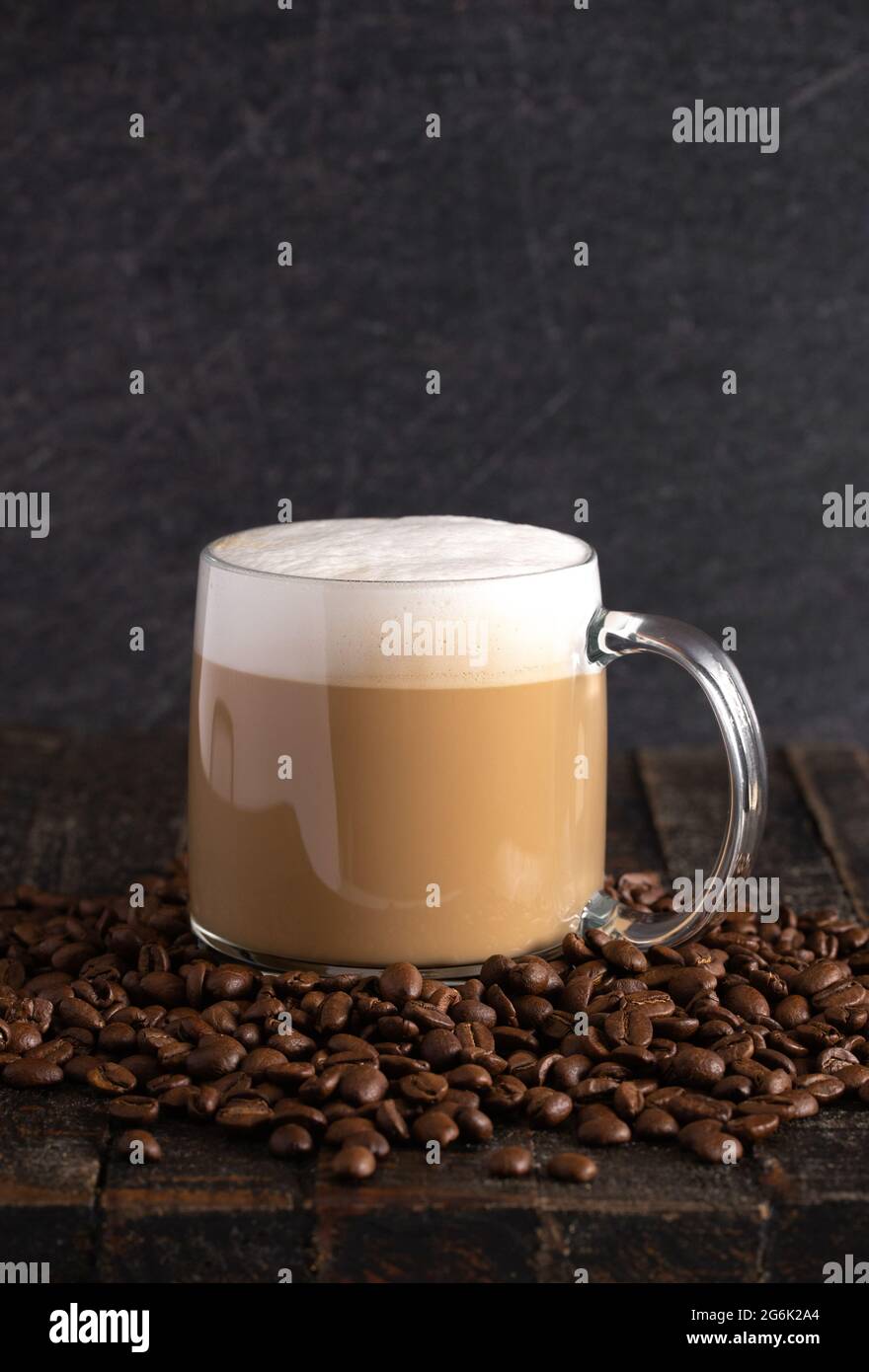 Café con leche en una taza de cristal transparente en un ambiente oscuro  Fotografía de stock - Alamy