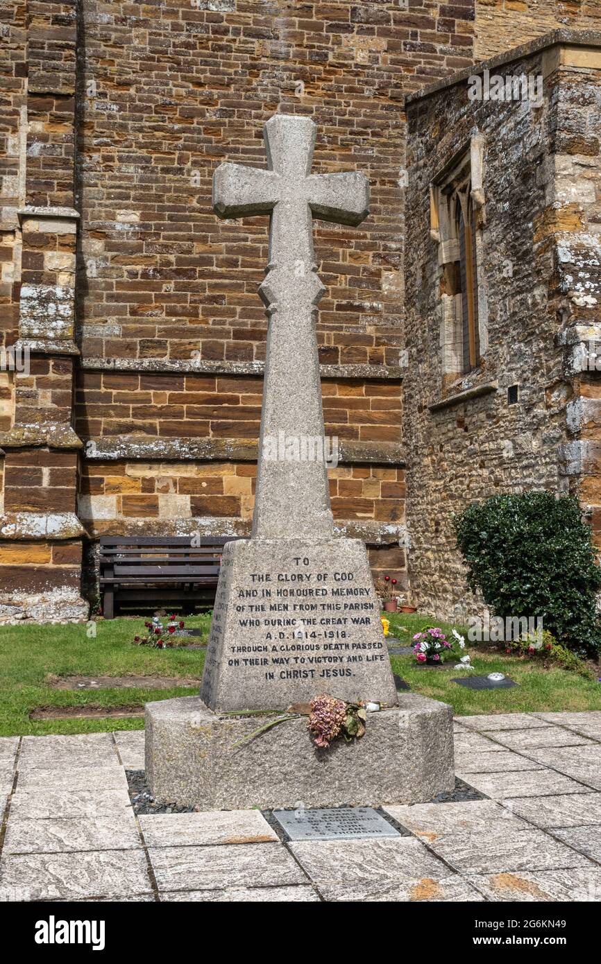 WW1 monumento conmemorativo en forma de cruz de piedra en las afueras de la iglesia de San Jorge el Mártir en el pueblo de Wootton, Northampton, Reino Unido Foto de stock