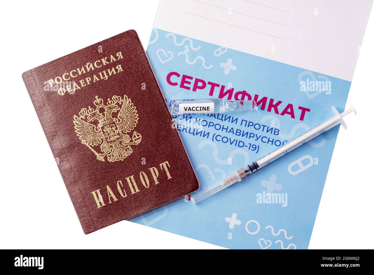 Un primer plano de una jeringa, ampollas con una vacuna y un pasaporte que se encuentra en el certificado de vacunación se aíslan sobre un fondo blanco. Inscripción i Foto de stock