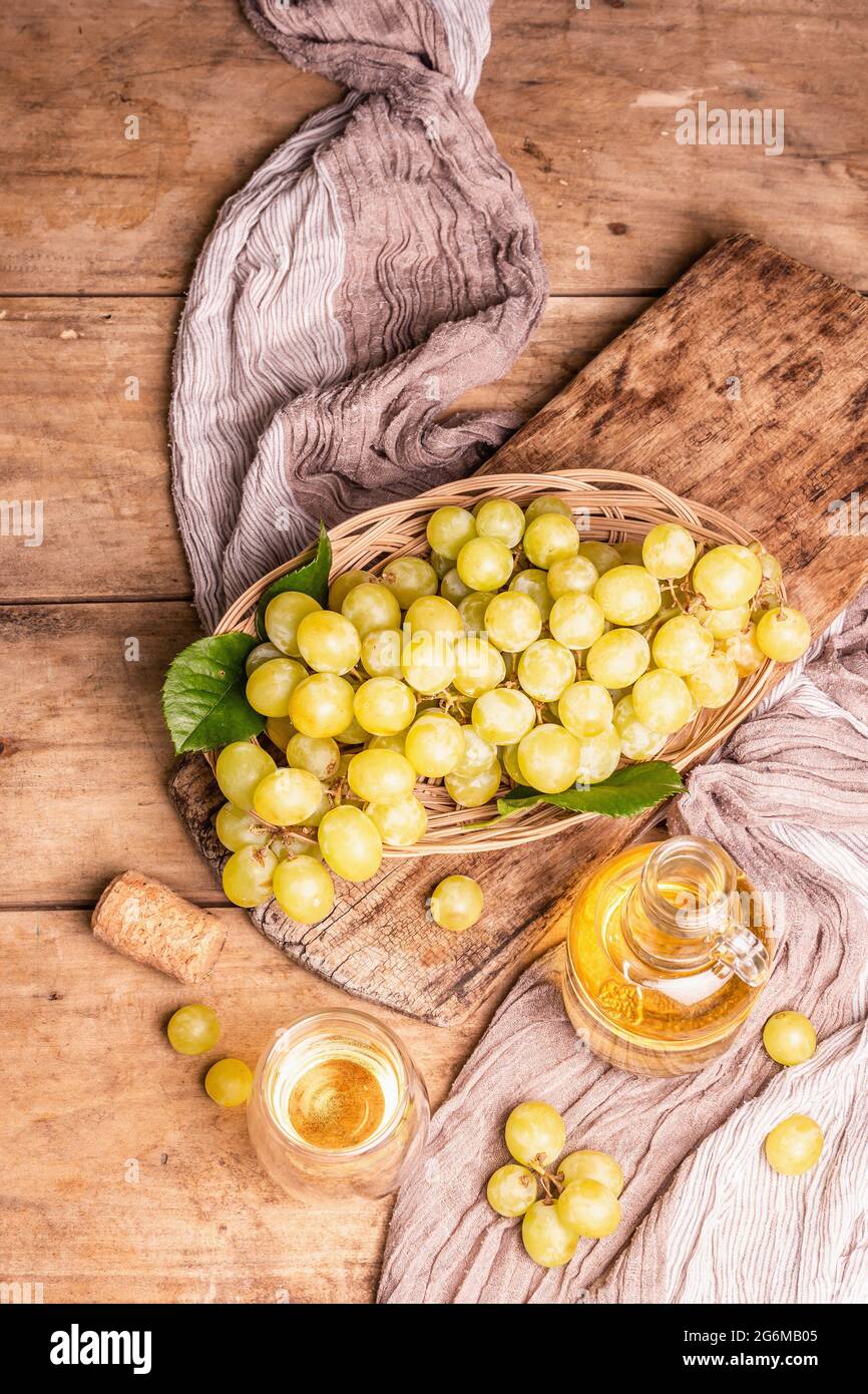 Vino blanco y uva en una cesta de mimbre. Fruta fresca, vidrio y botella.  Antiguas tablas de madera de fondo, vista superior Fotografía de stock -  Alamy