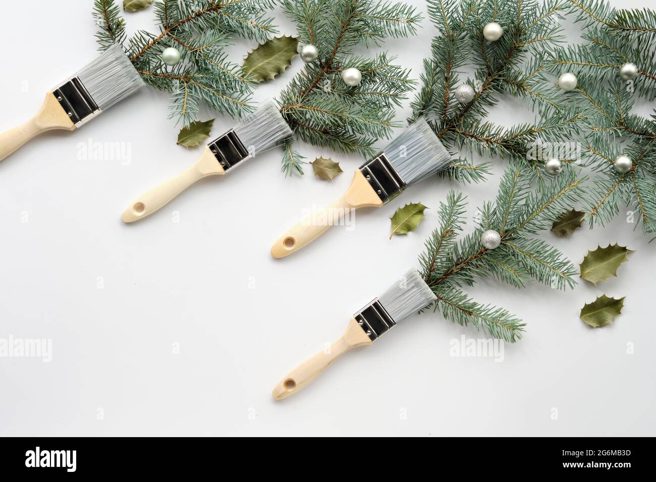 Pinceles con ramas de árbol de Navidad, abeto natural decorado con bolas de  plata y hojas de acebo. Creativo Simple fondo de invierno mínimo. Tiempo de  invierno Fotografía de stock - Alamy