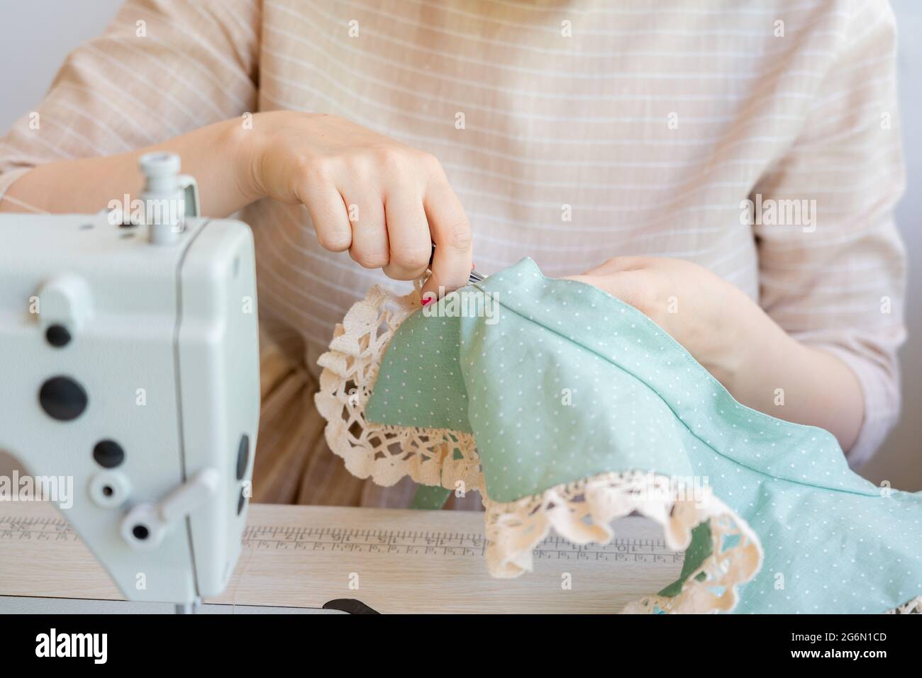 Manos femeninas haciendo cuello de encaje vintage mientras trabaja en su  lugar de trabajo con máquina de coser Fotografía de stock - Alamy