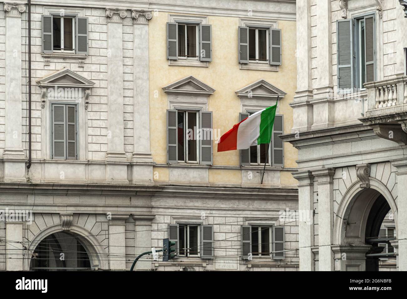 La bandera italiana revolotea entre los palacios de la Piazza dei Cinquecento en Roma. Roma, Lazio, Italia, Europa Foto de stock