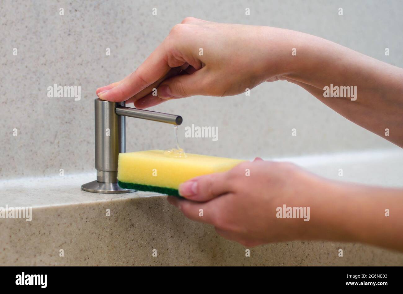 Una mujer usa un dispensador de jabón líquido en la cocina, una esponja  para lavar los platos. Mezclador de agua cromado brillante. Encimera de  mármol y fregadero Fotografía de stock - Alamy