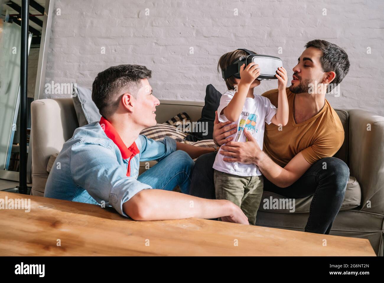 Pareja gay y sus hijos jugando videojuegos con gafas VR Fotografía de stock  - Alamy