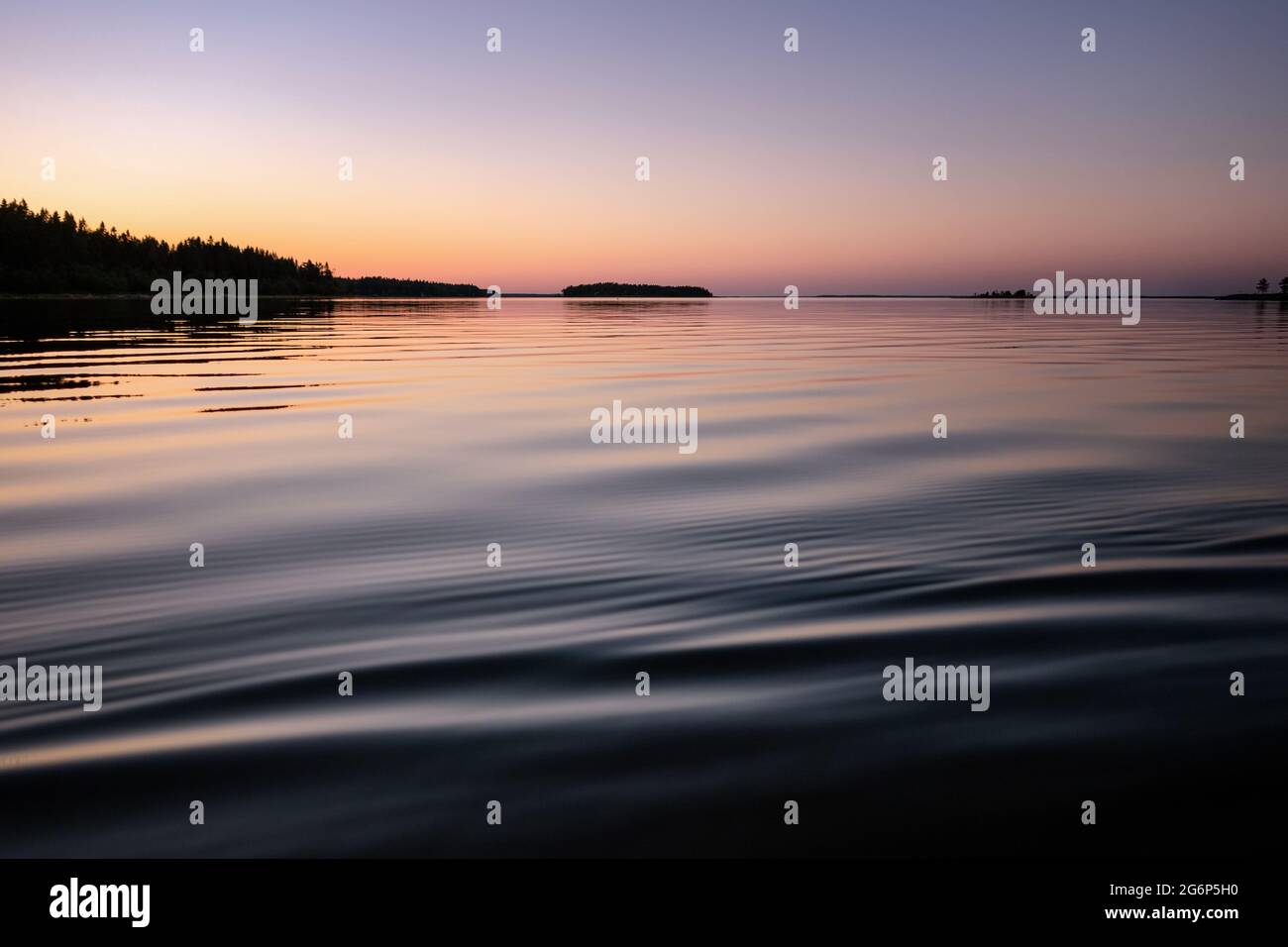 Sol mar medianoche en el norte de Suecia durante las noches de verano luz. Espejo como superficie de agua, rosa azul cielo rosa coloreado por el Sol sólo se escondió detrás del horizonte. Foto de stock
