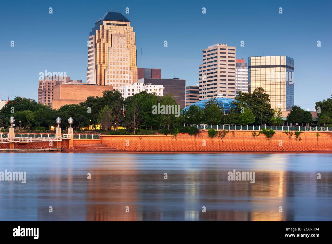 Shreveport, Louisiana, EE.UU., el horizonte del centro en el Río Rojo en el crepúsculo. Foto de stock