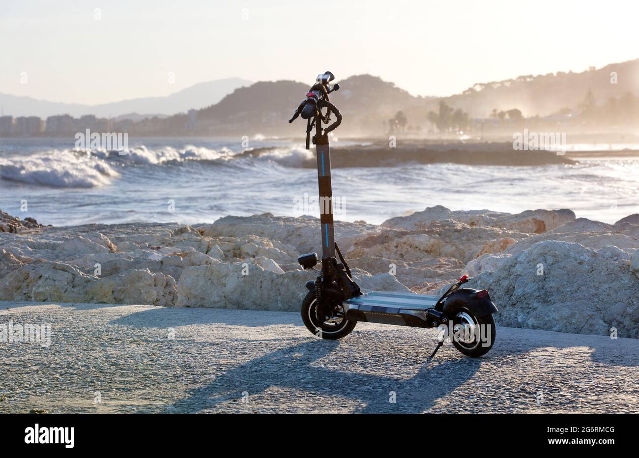 scooter eléctrico con mar con olas en el fondo al atardecer Fotografía de  stock - Alamy