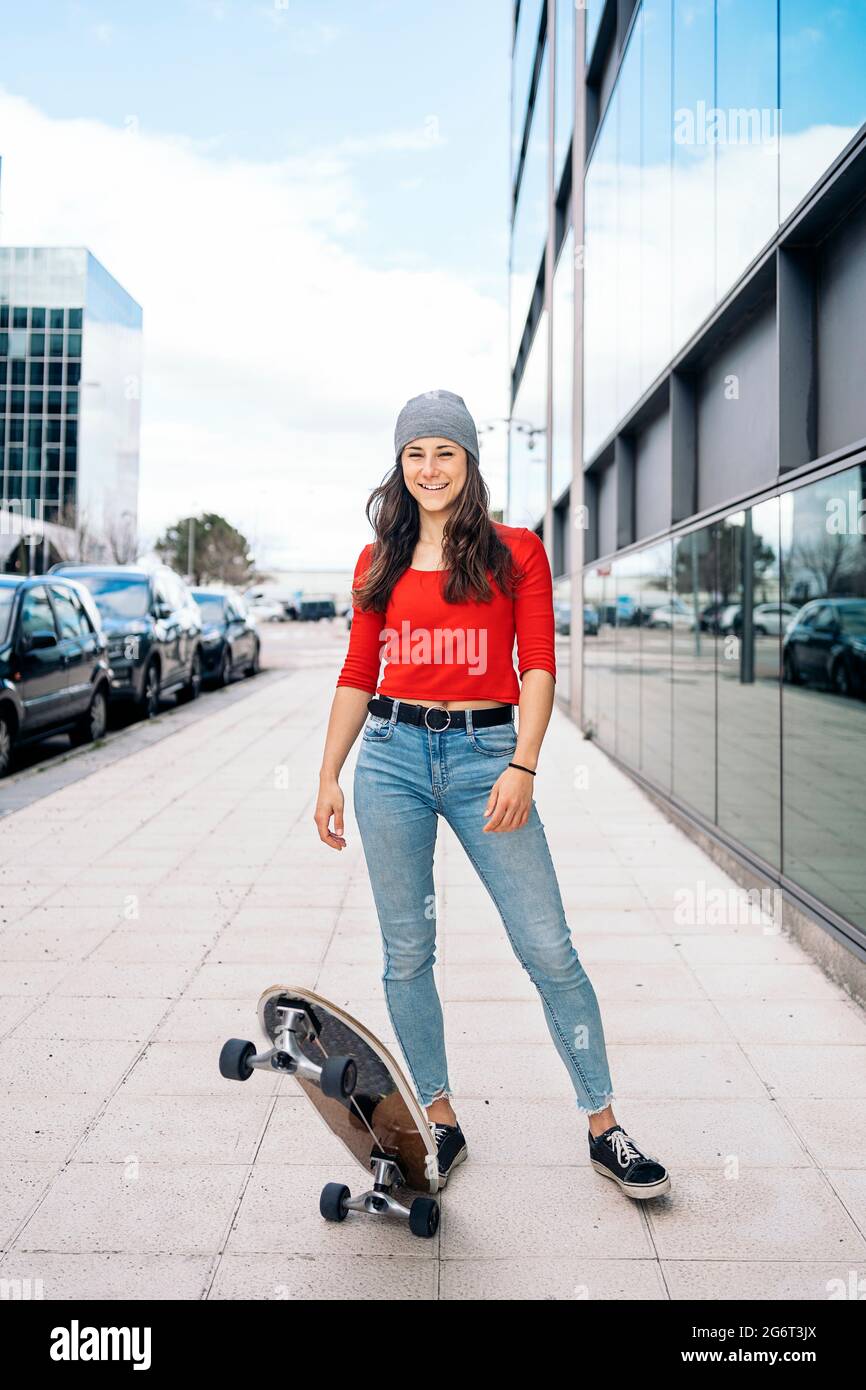 Bonita mujer joven con ropa informal sosteniendo su tabla larga y mirando  la cámara Fotografía de stock - Alamy