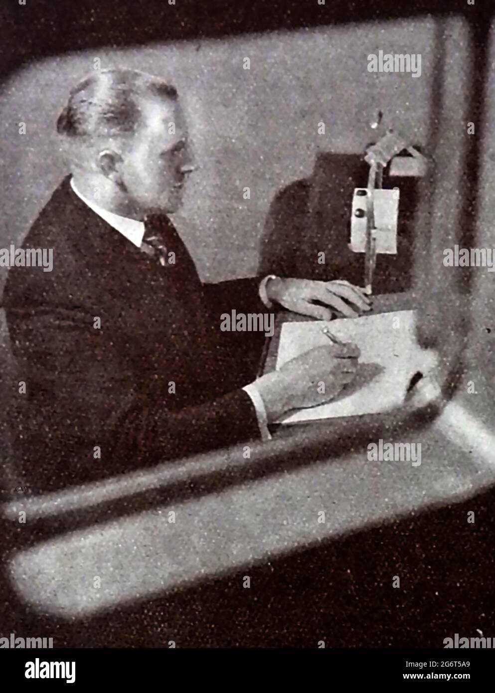Una fotografía muy temprana impresa de un locutor de la BBC que lee las  noticias . La BBC comenzó sus servicios de radio diarios en Londres en el  1920s en la estación