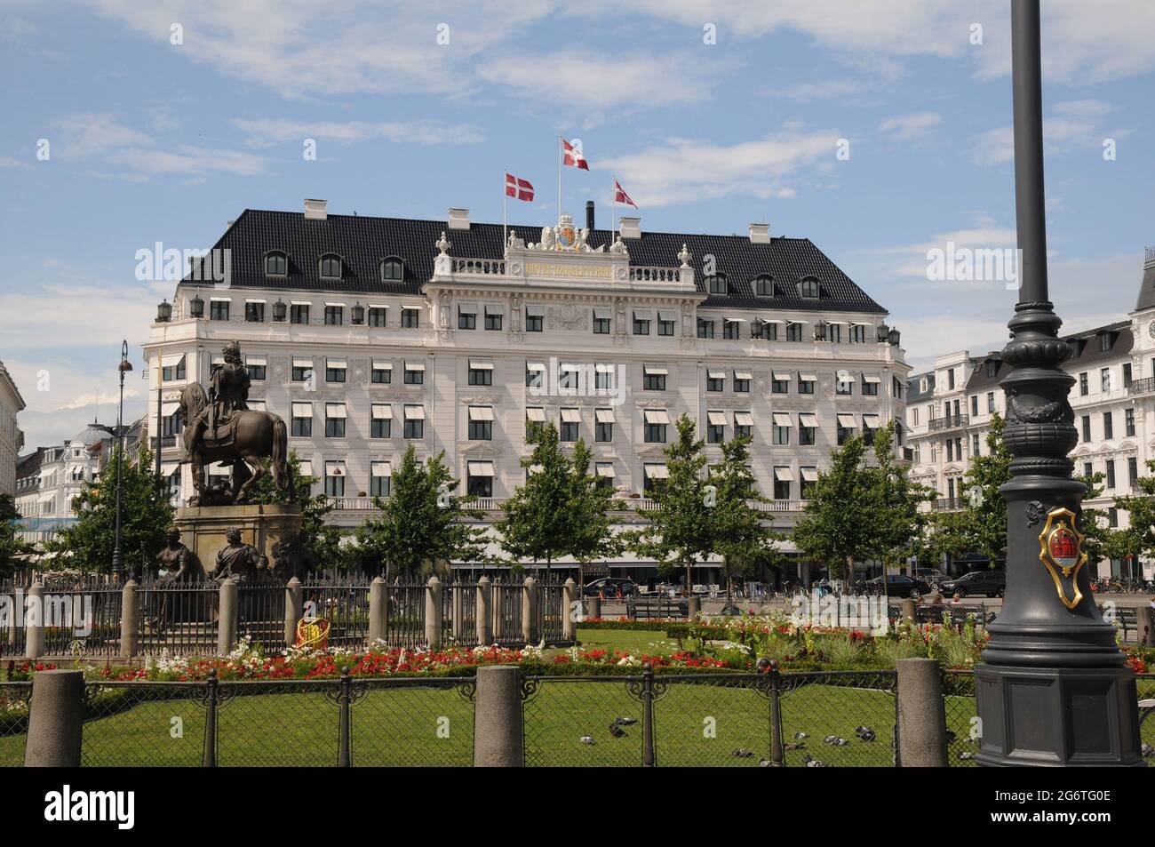Copenhague, Dinamarca. 08 2021, la gente disfruta de los veranos calurosos del sol en el Kongen nytorv con flores y plantas y el edificio blanco es grande llamado Hotelo Foto de stock