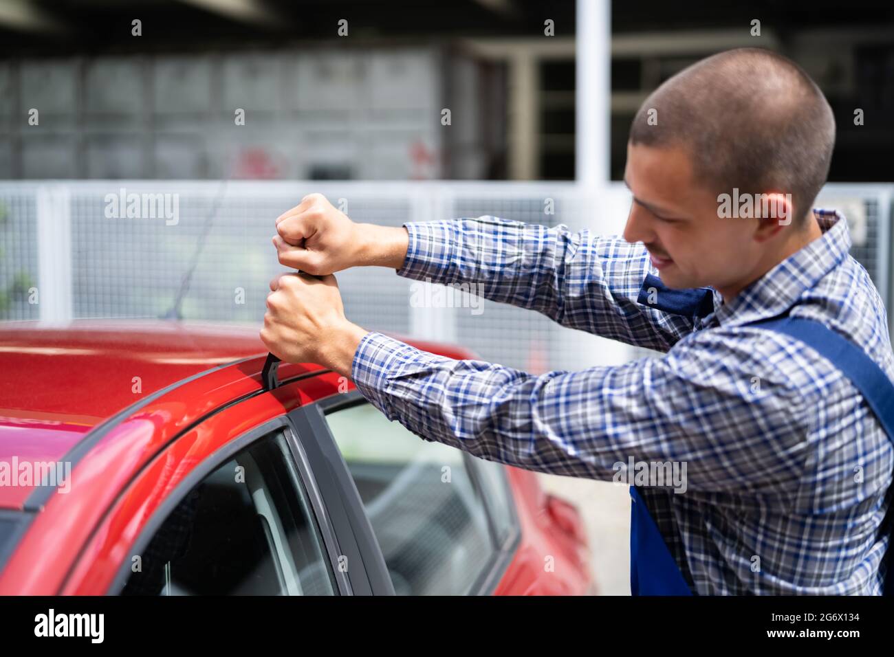 Cerrajero con la herramienta de cuña para abrir la puerta del vehículo  bloqueada Fotografía de stock - Alamy