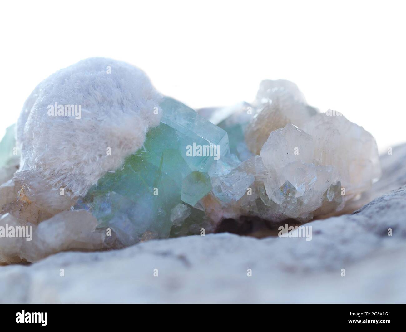 Hermosos minerales y cristales de stilbite y apophyllita parcialmente sobre un fondo blanco. Foto de stock