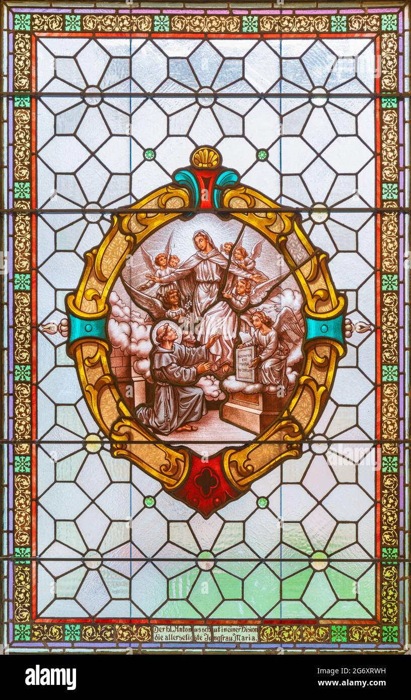 VIENA, AUSTIRA - JUNI 17, 2021: La visión de la visión de la Virgen María a San Antonio de Padua en el vitral de la iglesia Alserkirche Foto de stock