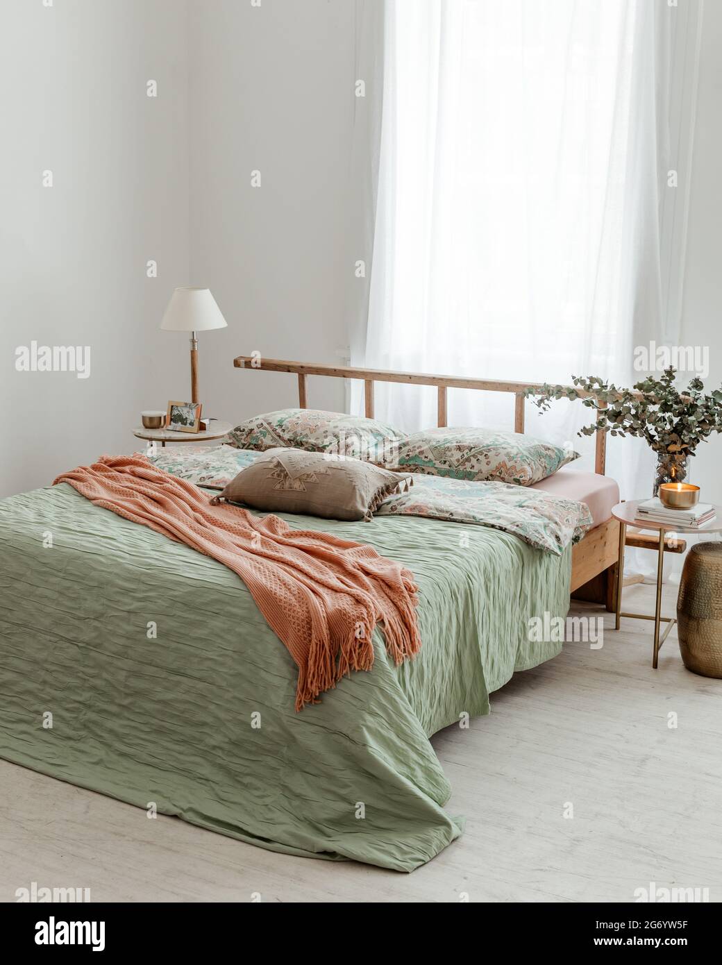 Cama de matrimonio con almohadas y sábanas junto a ventanas con cortinas Fotografía de stock - Alamy