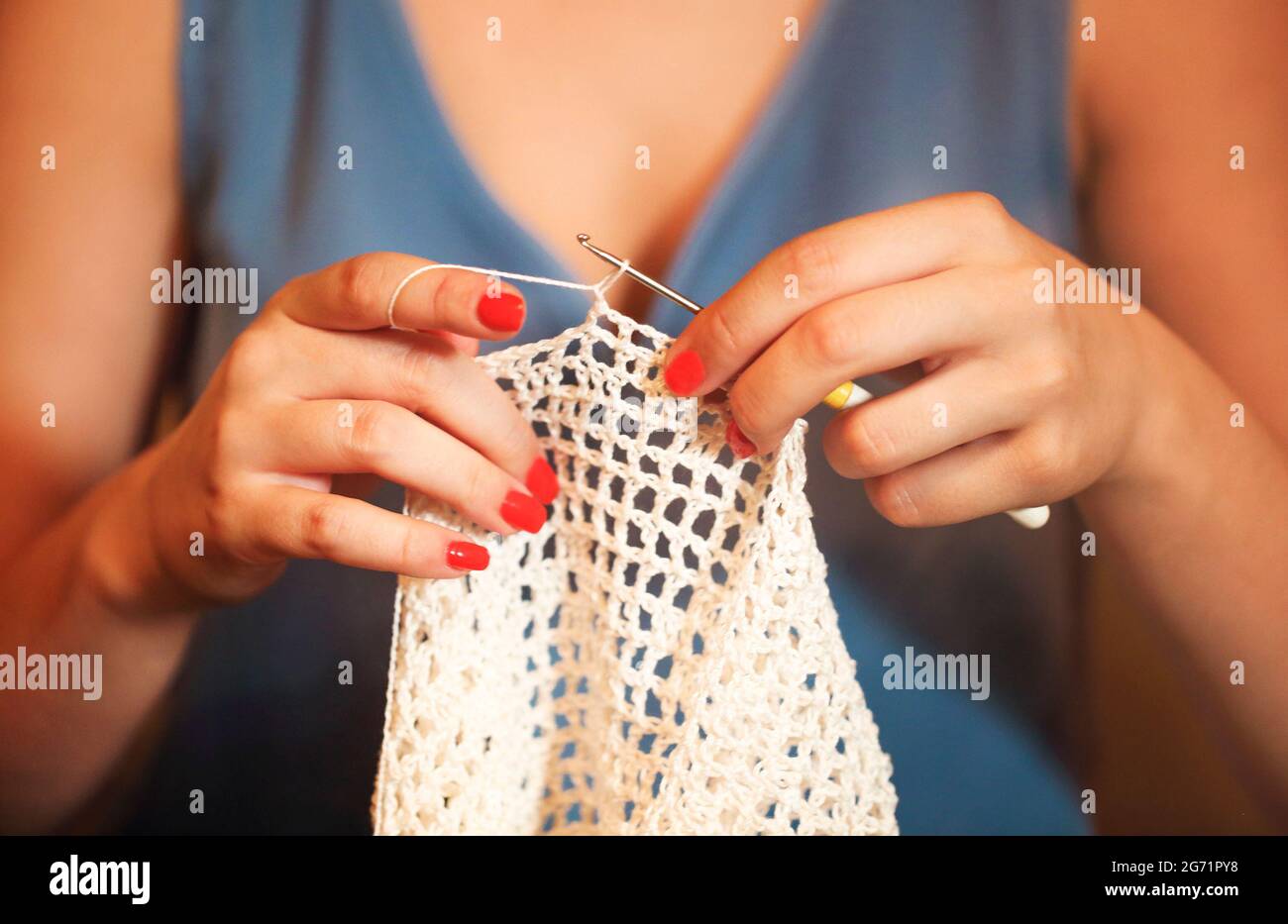 Mujer irreconocible con hilo de algodón blanco y gancho para ganchillo  delicada ropa de verano Fotografía de stock - Alamy
