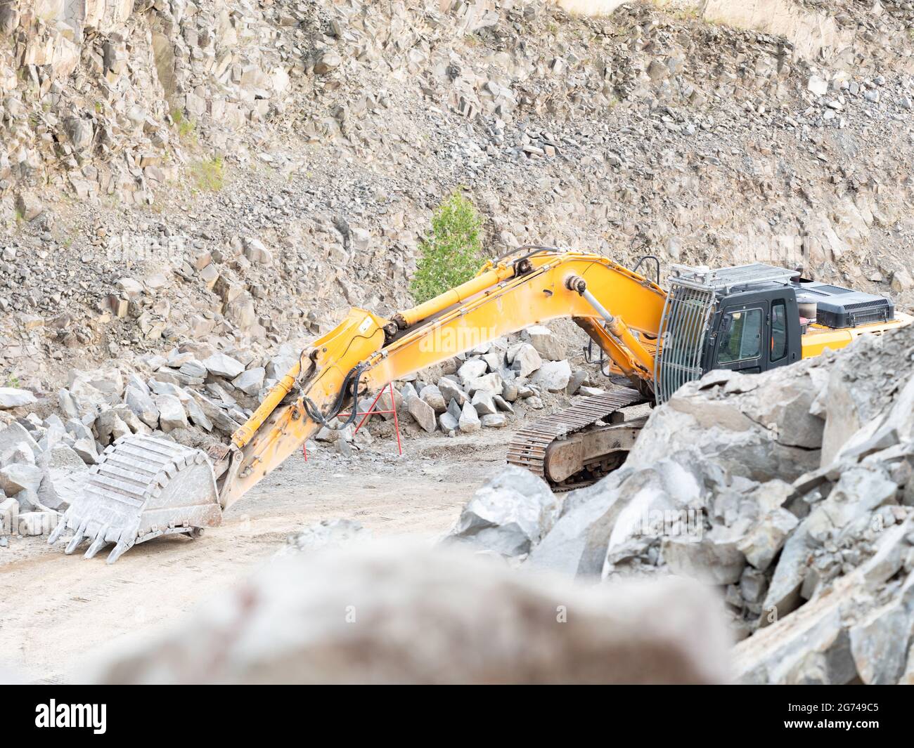 Excavadora durante trabajos de movimiento de tierras en minería a cielo  abierto sobre fondo de cantera de grava. Máquina cargadora con cucharón en  cantera. Retroexcavadora excavando el gruñal Fotografía de stock -