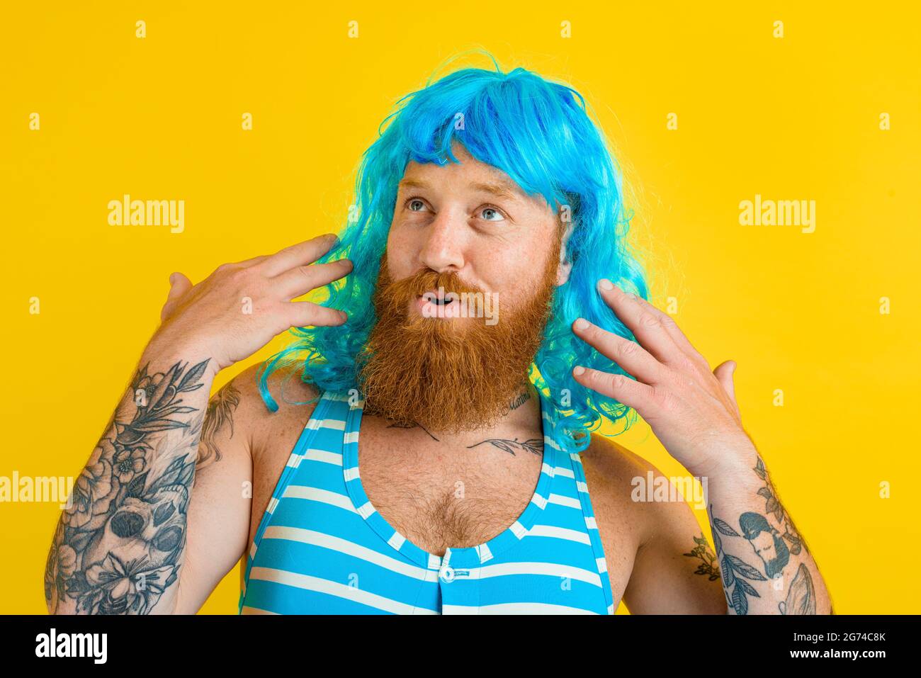 Hombre feliz con boya de la vida, traje de baño y peluca azul actúa como  una mujer feliz Fotografía de stock - Alamy