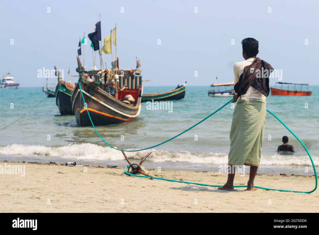 Pescadores y sus coloridos barcos de pesca. La industria pesquera en Bangladesh. Barco tradicional de pesca de Bangladesh en la isla de San Martín. Foto de stock