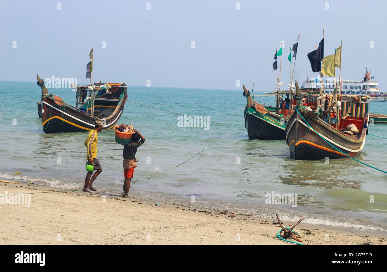 Pescadores y sus coloridos barcos de pesca. La industria pesquera en Bangladesh. Barco tradicional de pesca de Bangladesh en la isla de San Martín. Foto de stock