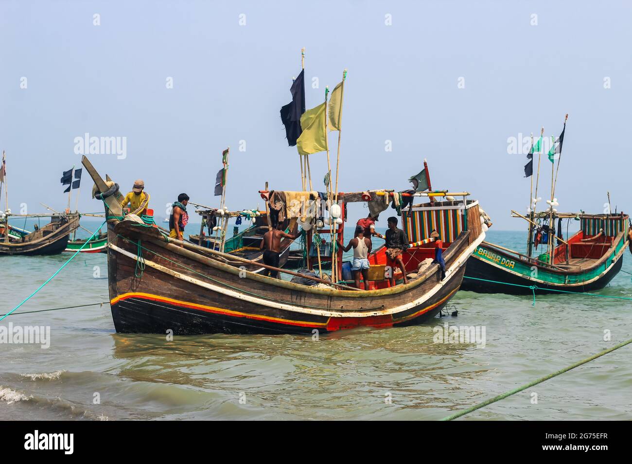 Pescadores y sus coloridos barcos de pesca. La industria pesquera en Bangladesh. Barco tradicional de pesca de Bangladesh en la isla de San Martín. Foto de stock