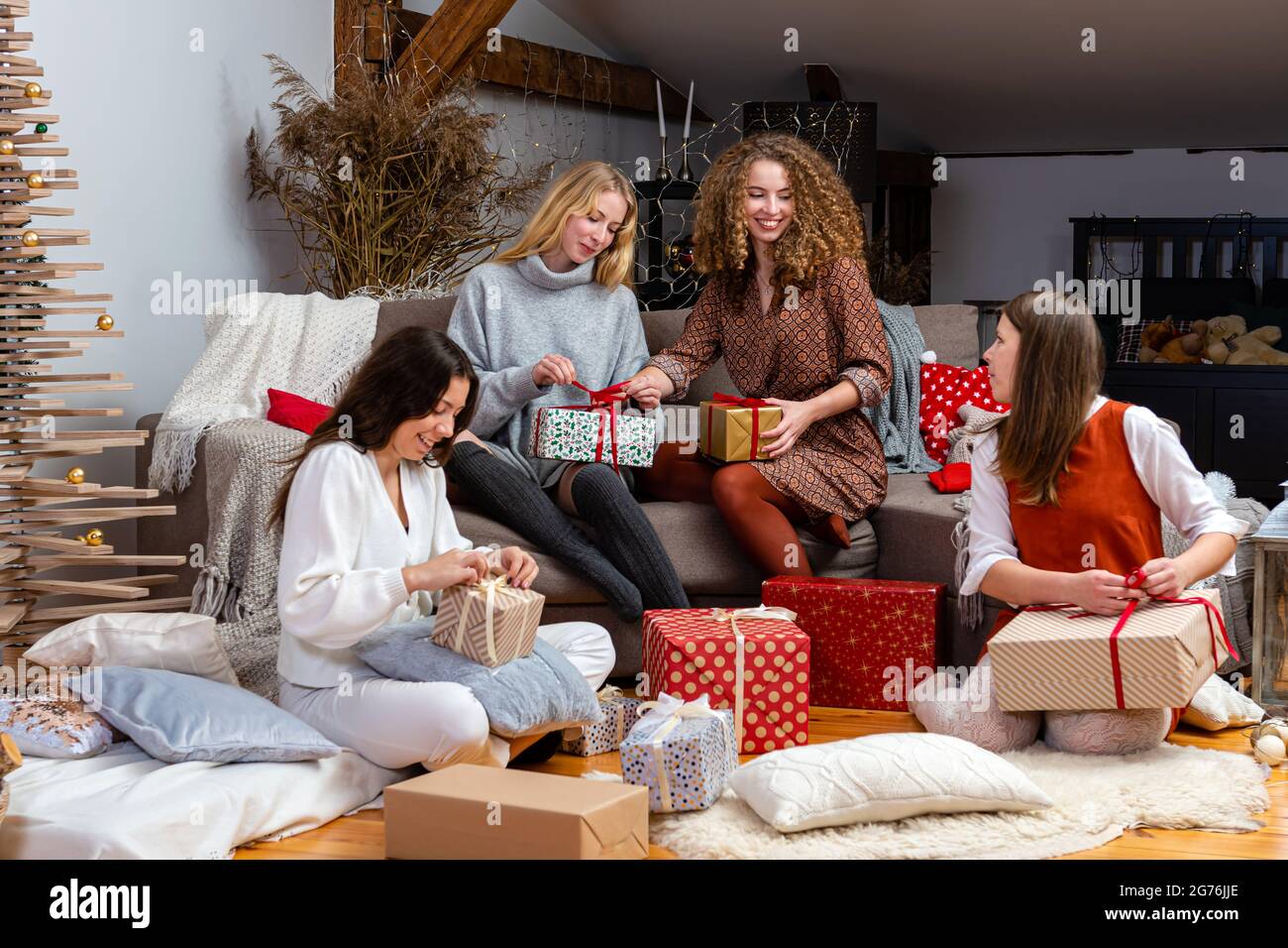 chicas jóvenes que se divierten envolver regalos en casa, gran trabajo en  equipo de amigos que empaquetan regalos para navidad, prepararse para el  próximo año nuevo y navidad Fotografía de stock -