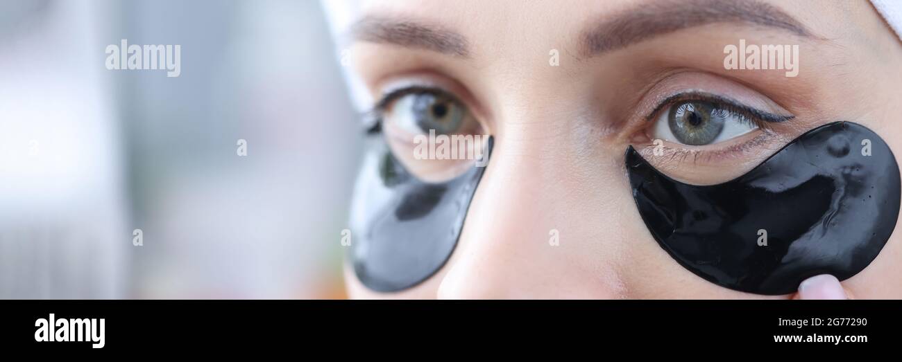 La mujer usa parches negros bajo los ojos para eliminar la hinchazón y.  arrugas suaves Fotografía de stock - Alamy