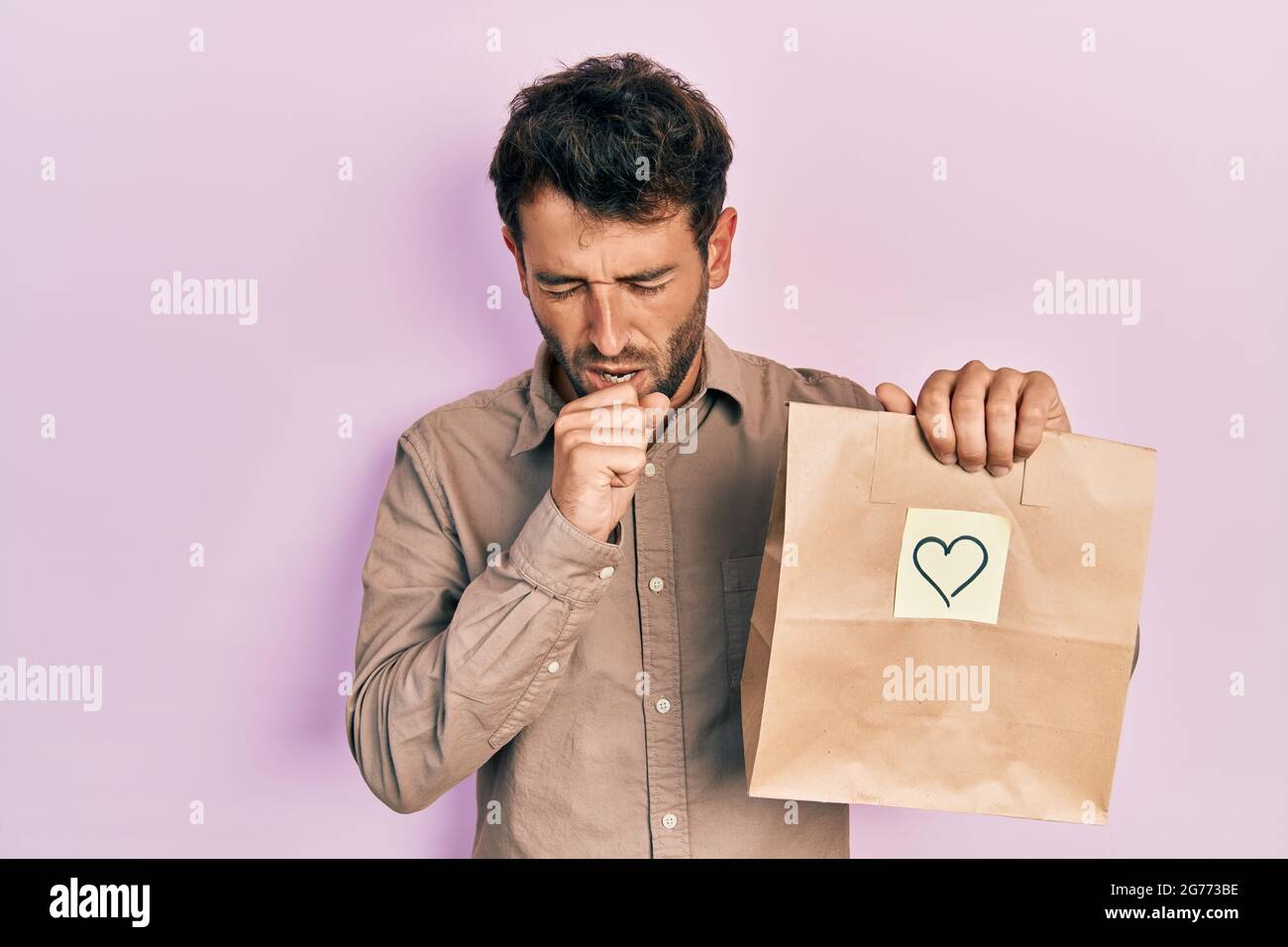 Hombre guapo con barba sosteniendo una bolsa de papel de parto con un Hombre guapo con barba sosteniendo una bolsa de papel de parto con un
