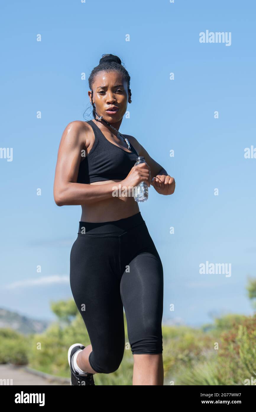 Desconocido lista Cerdo Tiro bajo de mujer afro americana en ropa deportiva running: Ejercicio y  concepto de fuerza Fotografía de stock - Alamy