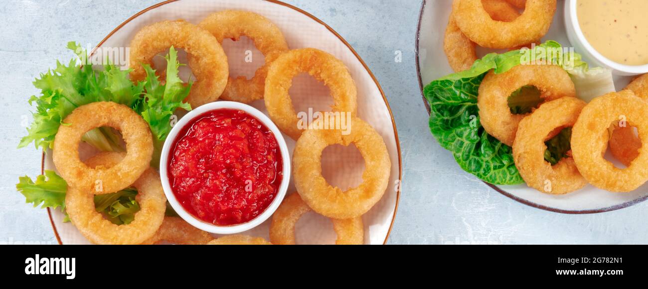 Panorama de anillos de calamar. Calamri con ensalada y salsa de marinara, tiro desde arriba. Aperitivo de marisco crujiente Foto de stock