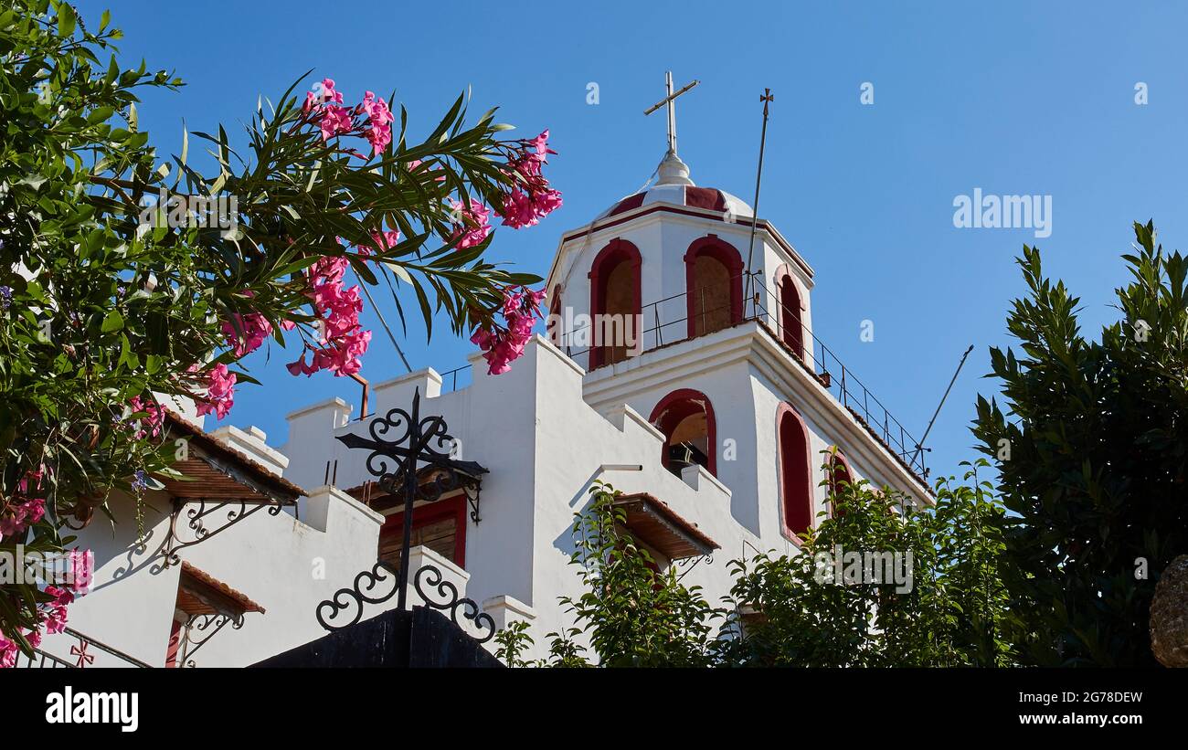 Islas Jónicas, Zakynthos, convento Eleftherotria, torre de la iglesia, adelfas en primer plano, cielo azul sin nubes Foto de stock