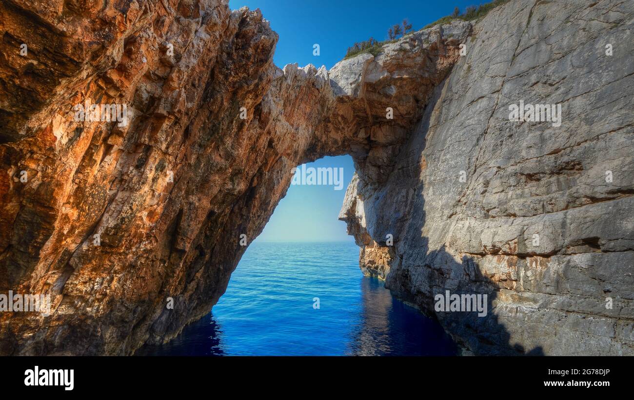 Islas Jónicas, Zakynthos, costa oeste, Mar Adriático, Korakonissi, isla de roca, puente rocoso, bajo el mar azul profundo, sobre el cielo azul profundo Foto de stock
