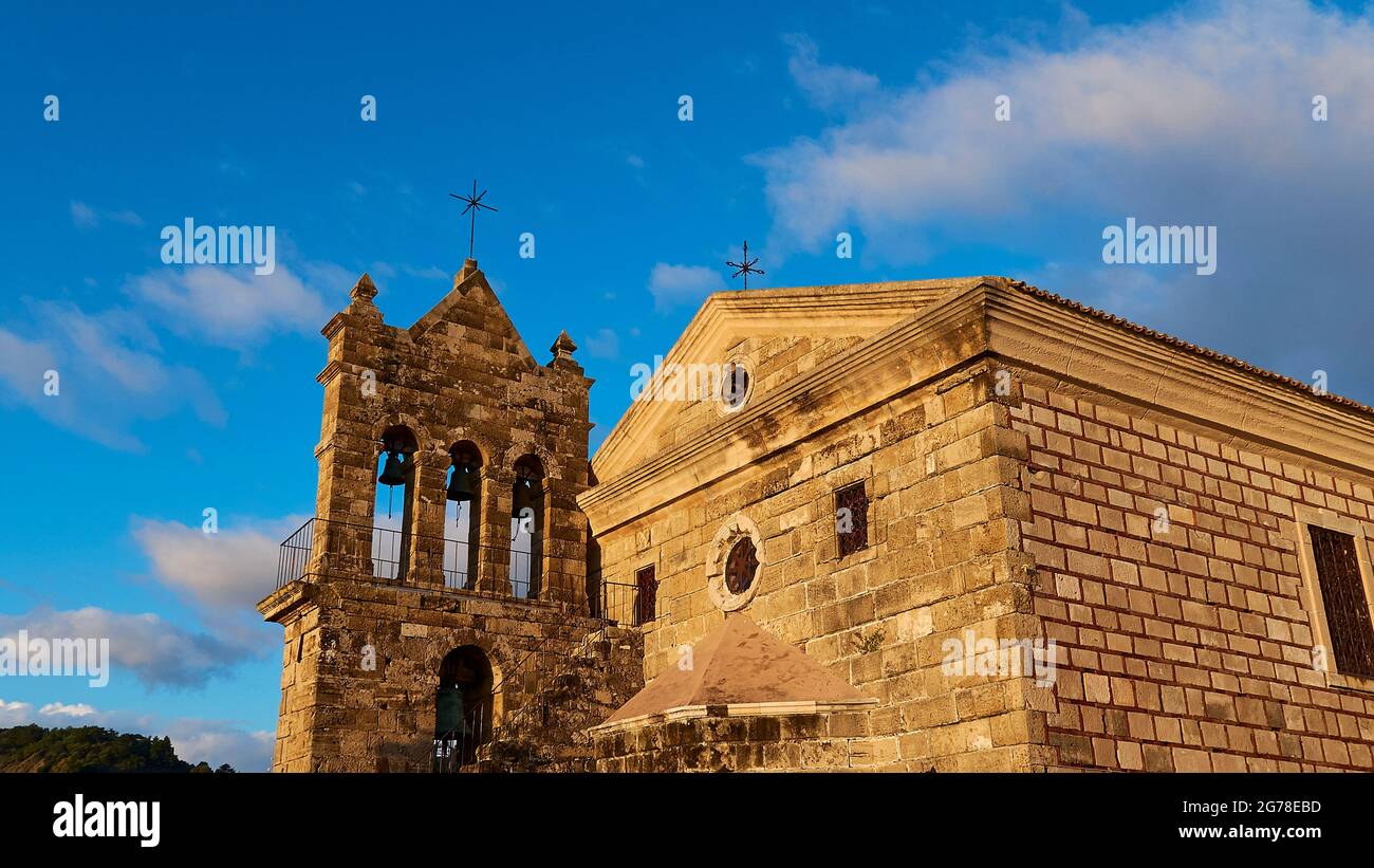 Zakynthos, la ciudad de Zakynthos, la iglesia de Agios Nikolaos de Molos, el campanario y el edificio principal de diagonalmente a los lados, la luz de la mañana, el cielo azul, las nubes del tiempo justo Foto de stock