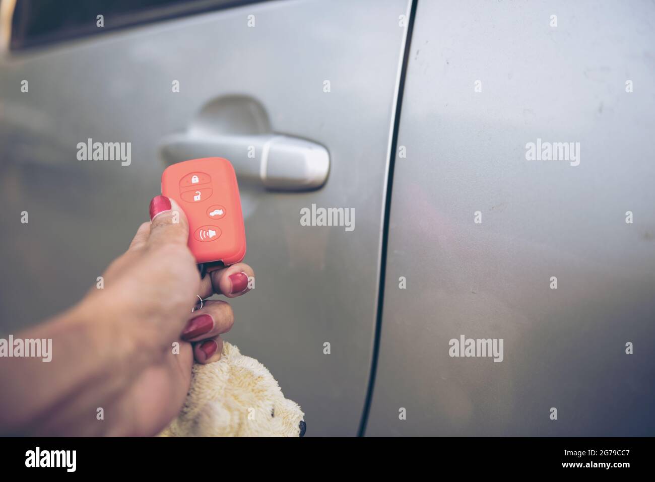 En el enfoque selectivo de las prensas de mano en el control remoto de los sistemas de alarma de coche. Procesamiento cruzado y Split tono instrumagrama como proceso. Con luz del sol Foto de stock