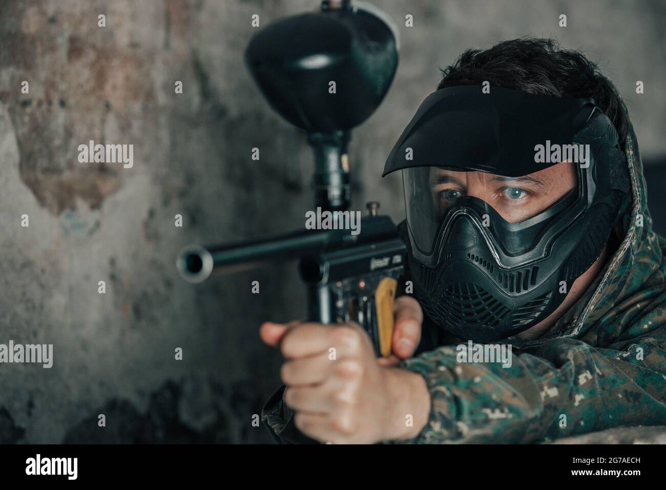 Retrato de hombre joven con máscara facial y pistola en el juego de acción  de paintball, simular el combate militar utilizando pistolas de aire para  disparar cápsulas de pintura en Fotografía de