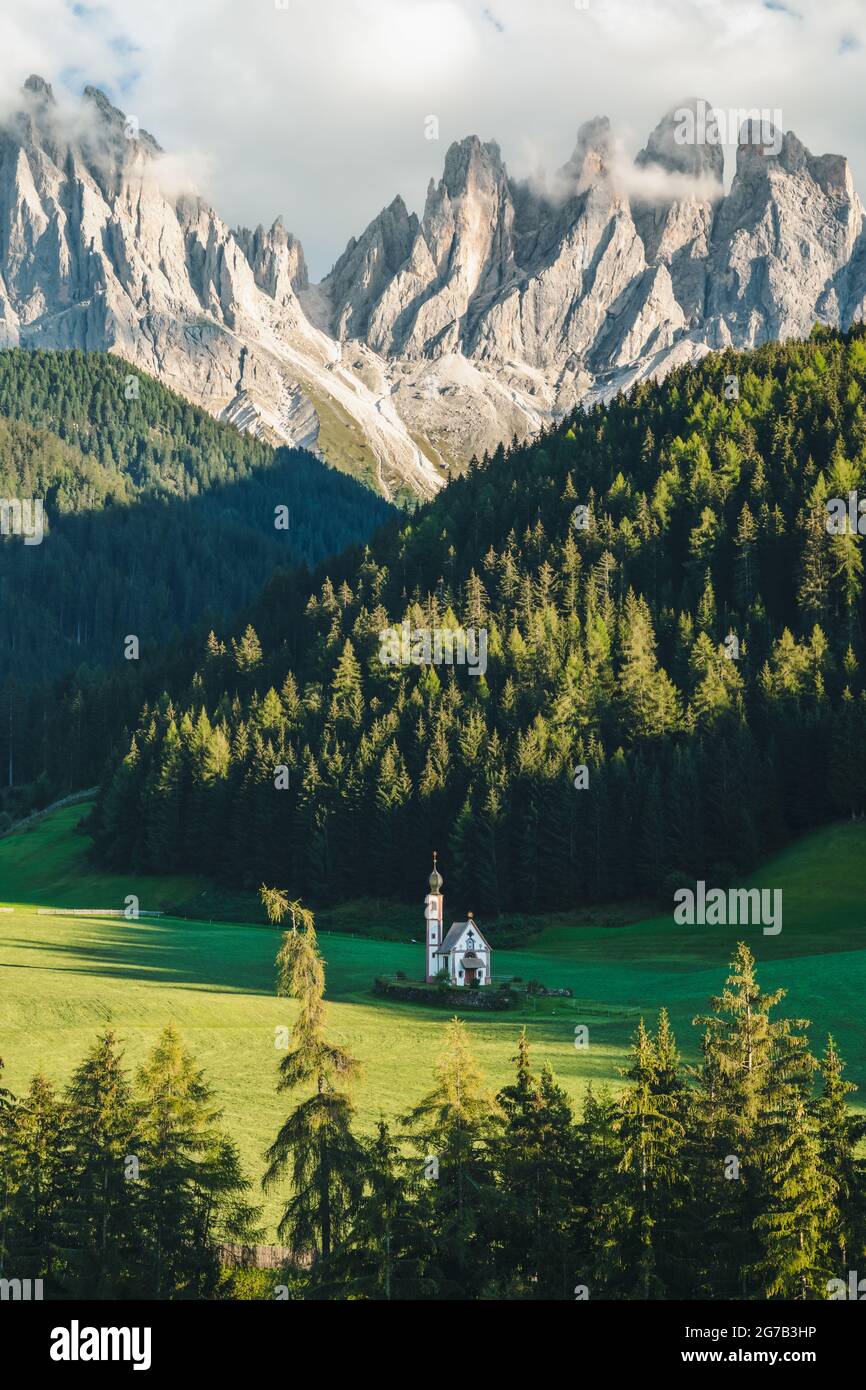 Iglesia de San Magdalena en el valle de Val di Funes, Dolomitas, Italia. Furchetta y Sass Rigais picos de montaña en el fondo Foto de stock