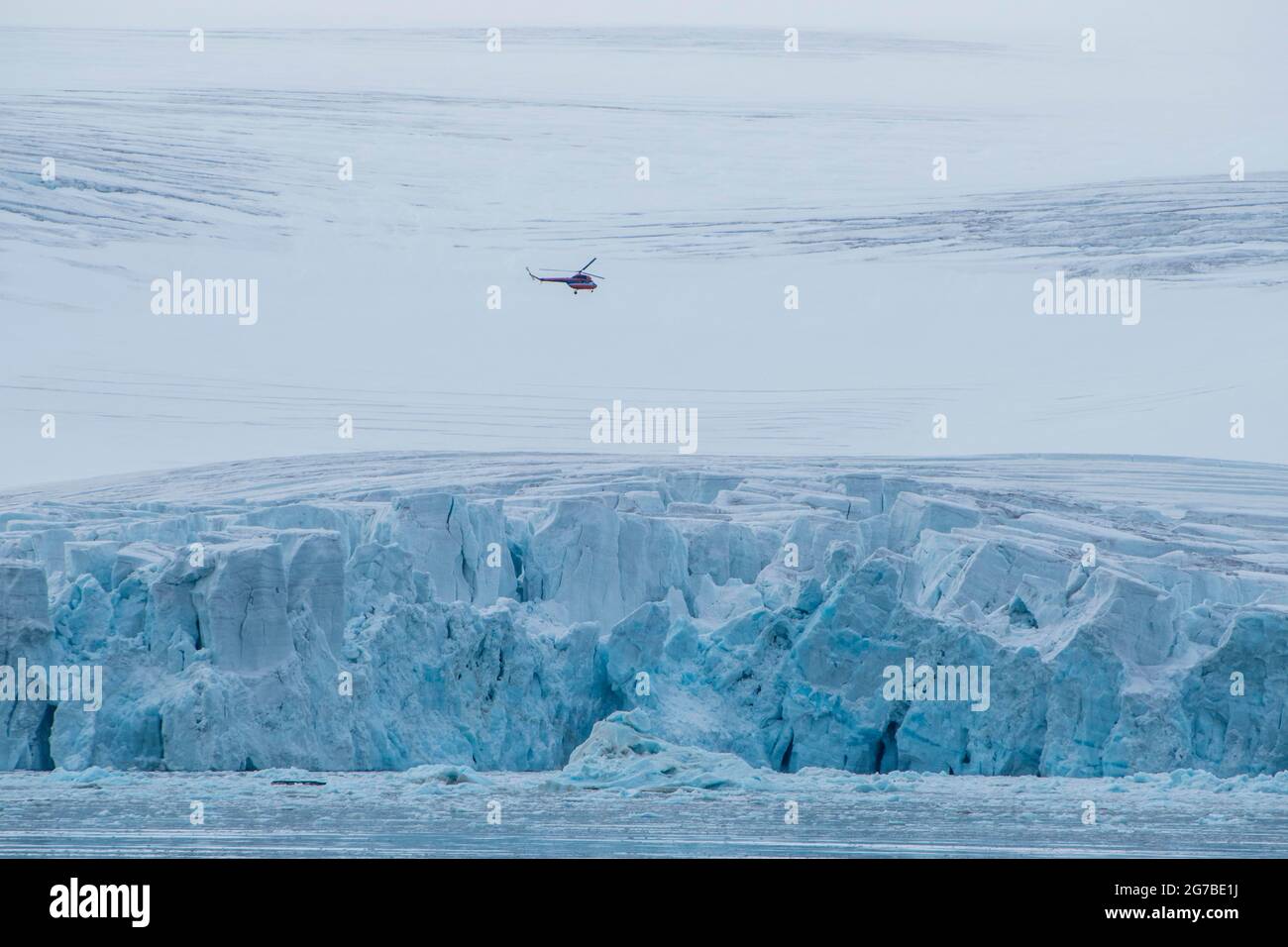 Helicóptero que vuela sobre el gigantesco campo de hielo de Alexandra Land, archipiélago de Franz Josef Land, Rusia Foto de stock