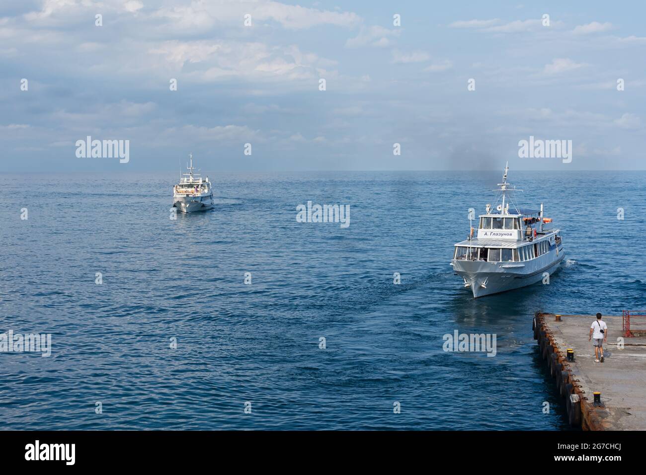 Yalta Crimea 04 de julio de 2019. Muelle de barco turístico. La gente viene y va desde el popular lugar turístico Swallow's Nest. Hermoso paisaje veraniego con mar Foto de stock