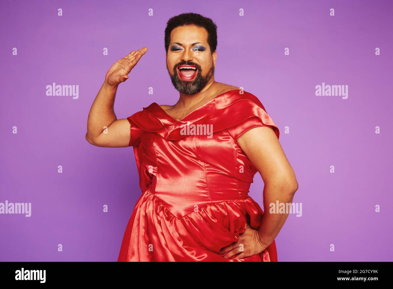 Fluido de género feliz en maquillaje y vestido de mujer roja. Hombre gay  cantando con ropa de mujer Fotografía de stock - Alamy