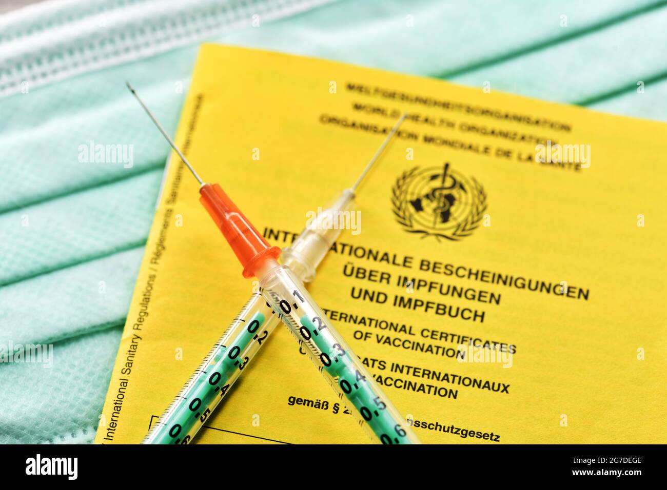 Jeringas cruzadas en la tarjeta de vacunación, combinación y combinación de vacunación Foto de stock