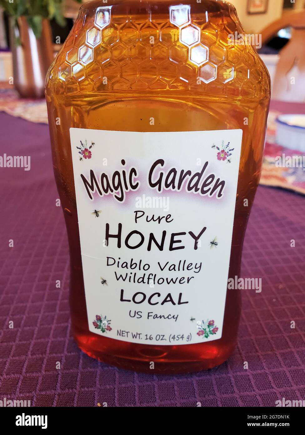 Primer plano de un contenedor de 16 onzas de 'Magic Garden Pure Honey Diablo Valley Wildflower' en una mesa residencial en Lafayette, California, 2 de abril de 2021. () Foto de stock