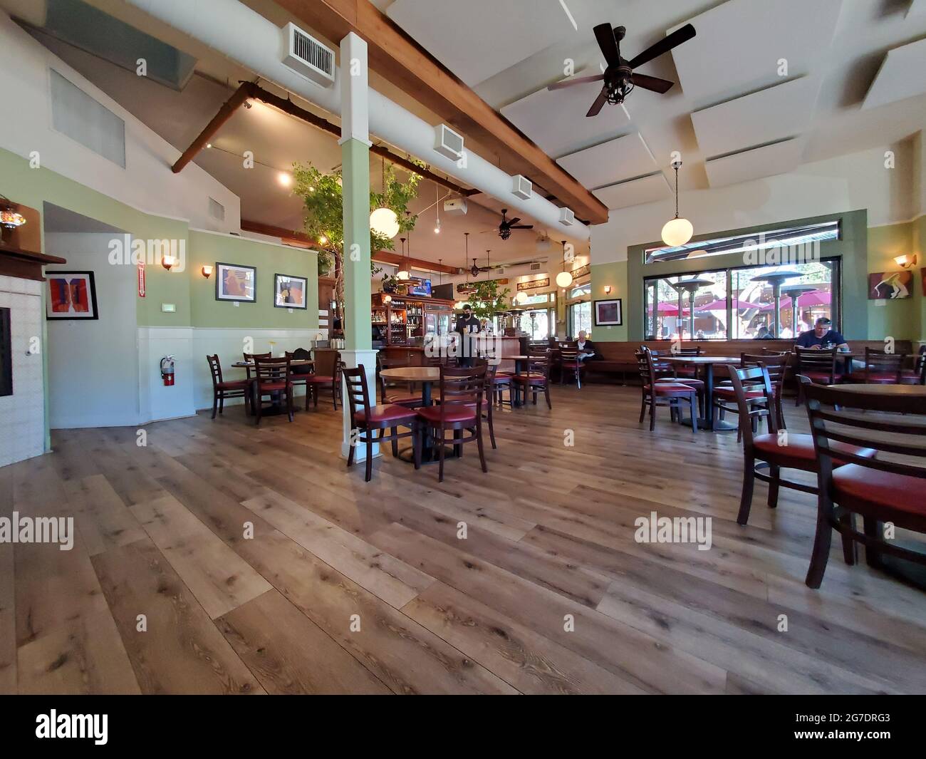 Amplia gama interior de mesas de comedor, algunas con clientes sentados, en Tutu's Food and Drink en Lafayette, California, 4 de mayo de 2021. () Foto de stock