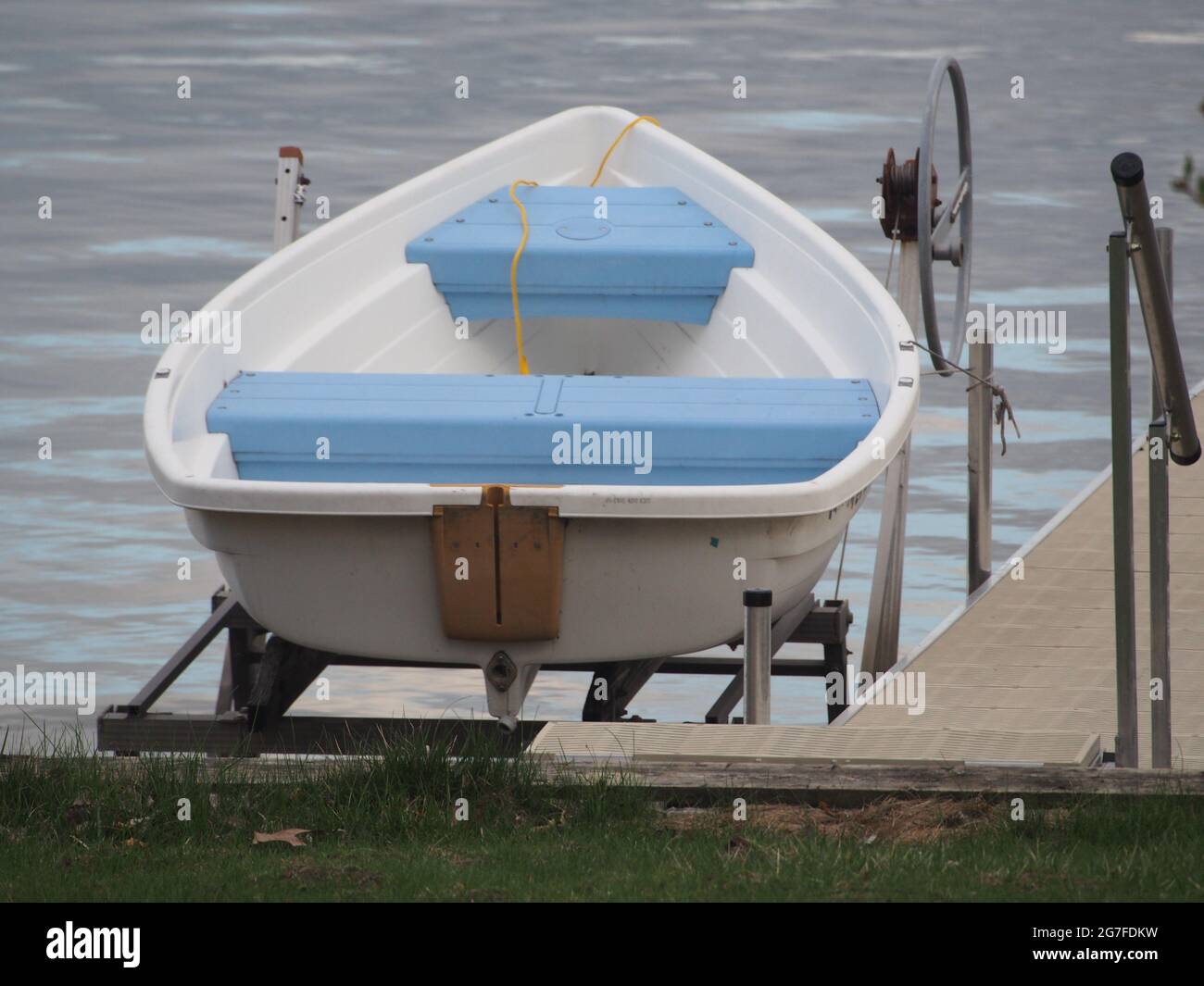 Bote a remo blanco con asientos azules en el elevador de barcos - Lake Life  Fotografía de stock - Alamy