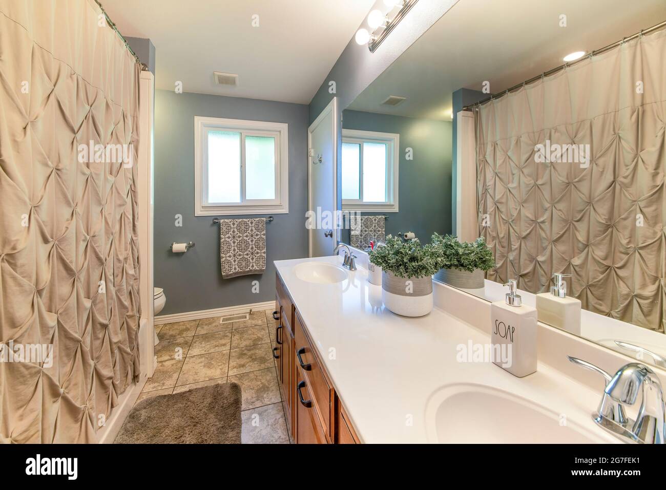 El interior del baño principal tiene una cortina de ducha y una ventana  elegantes Fotografía de stock - Alamy