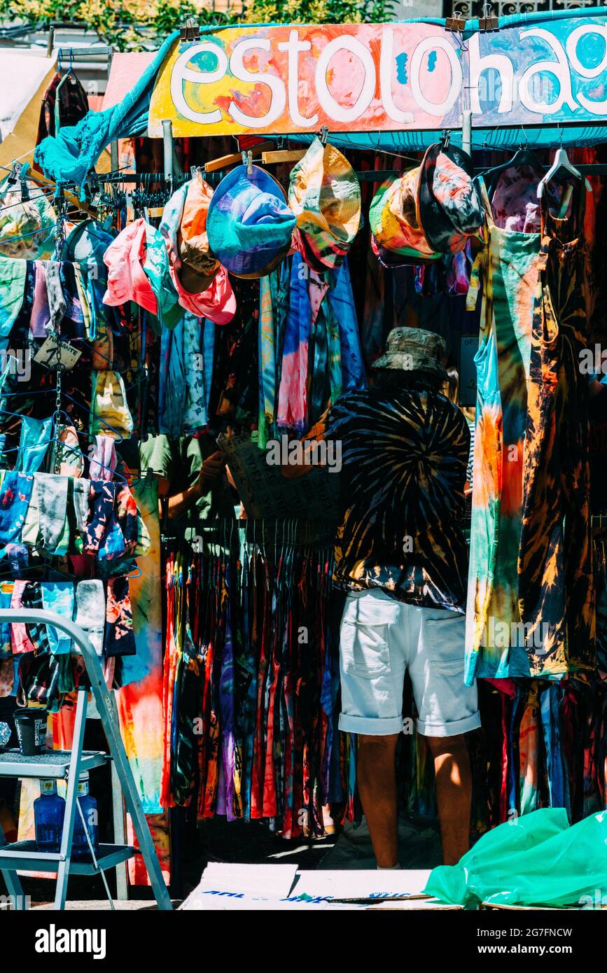 MADRID, ESPAÑA - 04 de julio 2021: Una foto de propietario de tienda de ropa hippie en el mercado El Rastro en Lavapies, Madrid Fotografía de Alamy