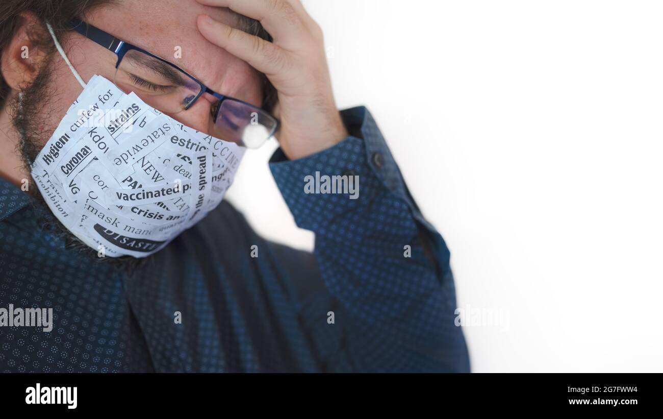 Un hombre sin idea con una máscara cubierta con noticias relacionadas con la crisis del virus de la corona. Foto de stock