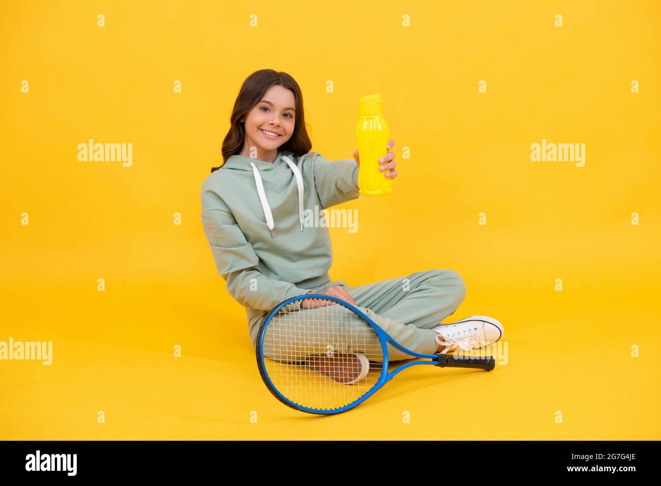 niño con raquetas de tenis. niña adolescente bebe agua después del  entrenamiento deportivo. jugador de bádminton relájese Fotografía de stock  - Alamy