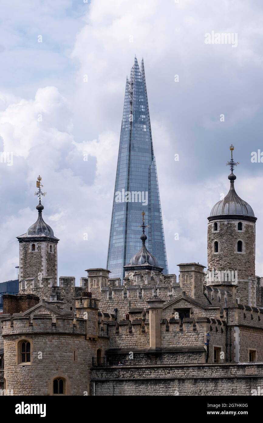 El Shard, visto a través de las torretas de la Torre de Londres, en Tower Hill, mostrando un contraste distintivo entre un monumento medieval y moderno Foto de stock