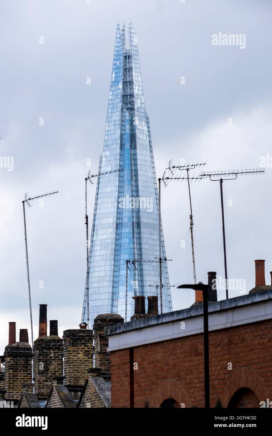 La torre Shard aparece como un monumento visto desde Waterloo mirando a través de las chimeneas y antenas de TV en la calle Roupell Foto de stock