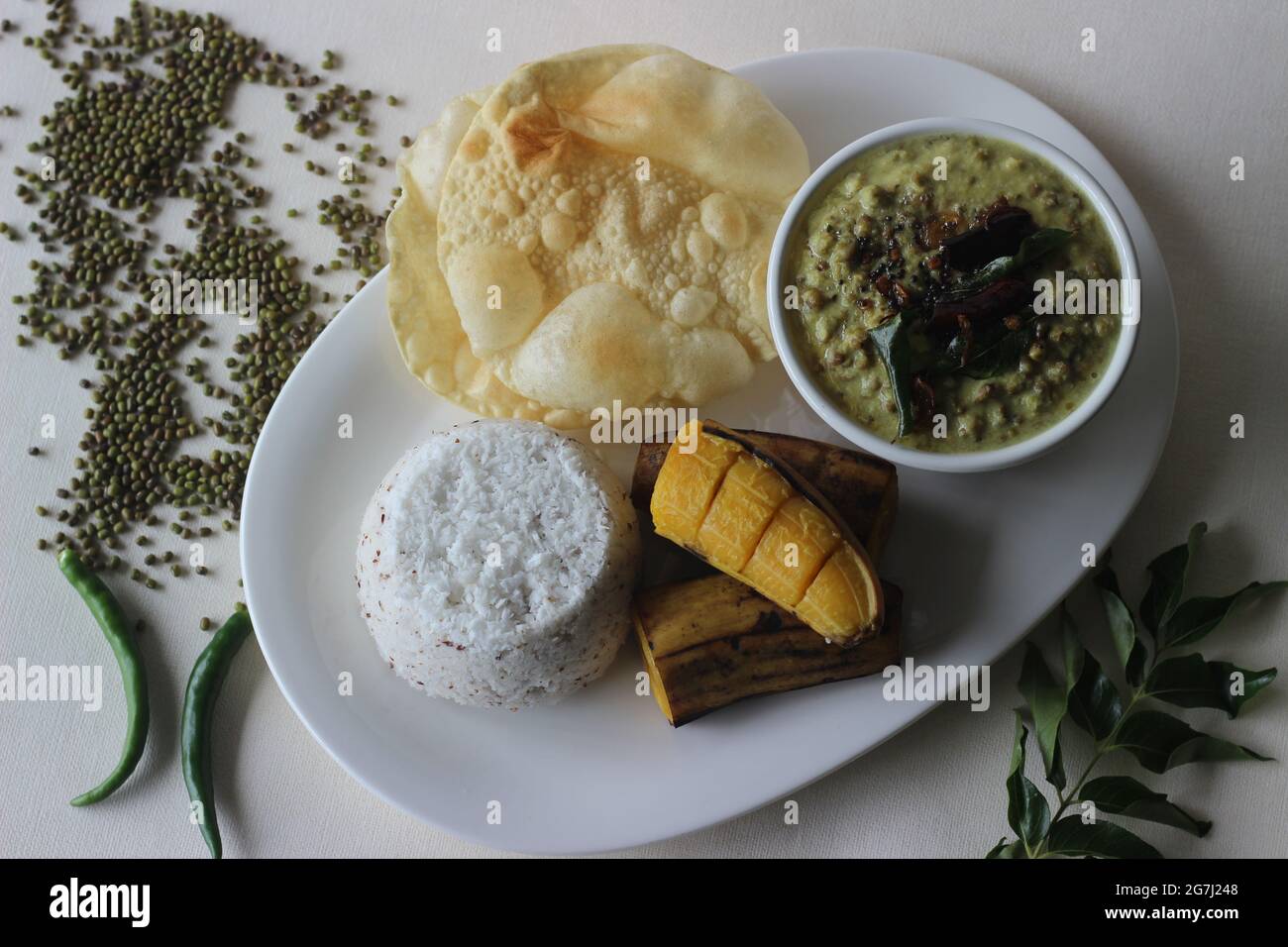 Pastel de arroz al vapor servido con plátano al vapor, curry de gramo verde  y papada. Un plato favorito de Kerala comúnmente conocido como puttu con  payar y pappadam Fotografía de stock -